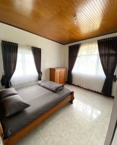 Tempat tidur dalam kamar di Villa Nada Situgunung.