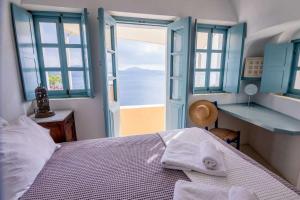 a bedroom with a bed with a view of the ocean at Zoe Aegeas Traditional houses in Oia