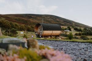 una casa redonda en las vías cerca de una colina en North Coast 500 Pods - Brora, en Brora