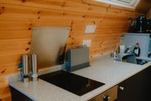 a kitchen with wooden walls and a counter top at North Coast 500 Pods - Brora in Brora