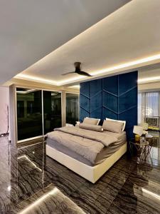 een slaapkamer met een groot bed met een blauwe muur bij Bangi Evo Luxury Suite in Bandar Baru Bangi