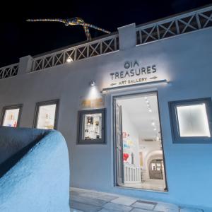 a store with a sign on the side of a building at Oia Treasures Art Suites in Oia