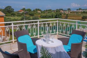 a table and chairs on a balcony with a view at Ria Villa Preveza in Kalamitsi