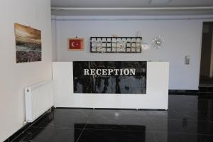 una stanza con una parete bianca con un cartello che legge la ricezione di Kommageneiz hotel ad Adıyaman