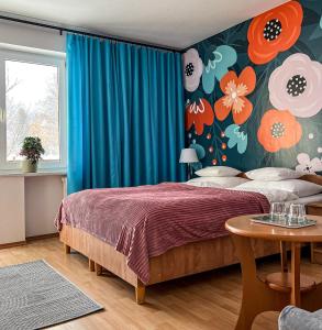a bedroom with a bed with a floral wall at Willa RADosna in Karpacz