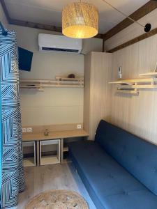 une chambre avec un canapé bleu et une table dans l'établissement L'imprévu, à Vaulnaveys-le-Bas