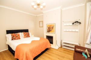 sypialnia z łóżkiem z pomarańczowym kocem w obiekcie Laburnum View - TSAC w mieście Redcar