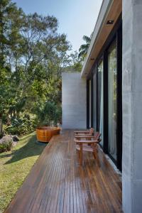 a wooden deck with benches on the side of a house at Casa Marambaia Hotel in Petrópolis