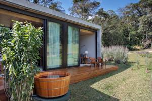 a house with a wooden deck with a patio at Casa Marambaia Hotel in Petrópolis