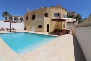 ein Pool vor einem Haus in der Unterkunft 4 Bedroom, Luxury Villa - Heated Pool in Villamartin