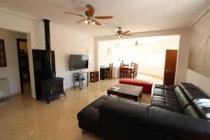 ein Wohnzimmer mit einem schwarzen Ledersofa und einem Kamin in der Unterkunft 4 Bedroom, Luxury Villa - Heated Pool in Villamartin