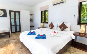 a bedroom with a large white bed with towels on it at Lazy Day The Resort in Ko Mak