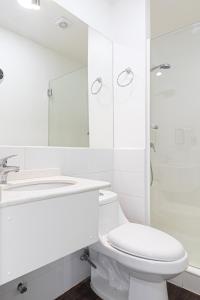 uma casa de banho branca com um WC e um lavatório em Hotel Ossido Nero em Viña del Mar