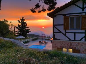 a sunset over a house with a swimming pool at Vissala Village in Chortáta