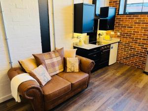 a living room with a couch and a desk at Apartment 5 Sullivan House in Hereford