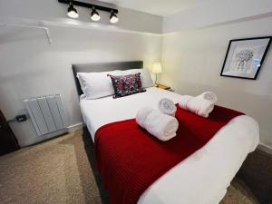 una camera da letto con un grande letto con asciugamani di Apartment 5 Sullivan House a Hereford