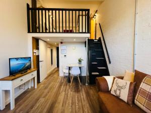 ein Wohnzimmer mit einem Sofa, einem Tisch und einem TV in der Unterkunft Apartment 5 Sullivan House in Hereford