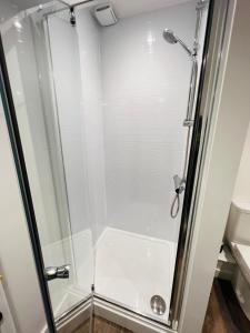 a shower with a glass door in a bathroom at Apartment 5 Sullivan House in Hereford