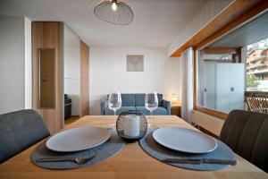 uma sala de jantar com uma mesa e dois copos de vinho em Charmant studio rénové situé dans les bains d'Ovronnaz, immeuble les Sources em Ovronnaz