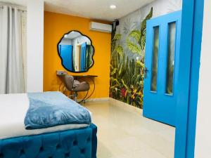 1 dormitorio con puerta azul y pared amarilla en ILLIYIN Boutique Hotel, en Dakar