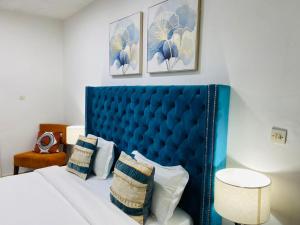 - un lit bleu avec des oreillers dans la chambre dans l'établissement ILLIYIN Boutique Hotel, à Dakar