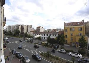 vistas a una calle de la ciudad con coches y edificios en Mairie de Saint-Ouen (Métro 13/14), en Saint-Ouen