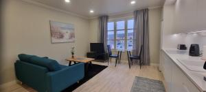- un salon avec un canapé bleu et une table dans l'établissement Apartment Louna, à Lahti