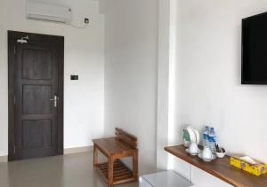 a room with a door and a table and a television at Atteriya SIGIRIYA in Sigiriya