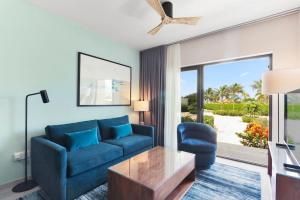 a living room with a blue couch and a table at Bocobay Gold Coast Resort in Palm-Eagle Beach