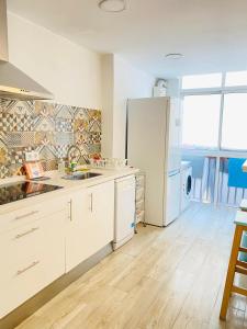 uma cozinha com armários brancos e um frigorífico em Betis a la Orilla del Guadalquivir & Vistas a la Giralda em Sevilha