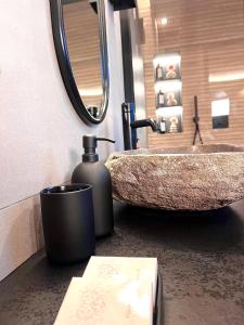 ein Badezimmer mit einem Waschbecken und einem Seifenspender in der Unterkunft Maison Nina, Suite d’exception in Villeneuve-la-Garenne