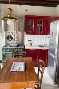 una cucina con armadi rossi e un tavolo in legno con sidro di sidro. di Appartamento Chioggia a Chioggia