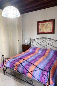 un letto con un piumone colorato in una camera da letto di Appartamento Chioggia a Chioggia
