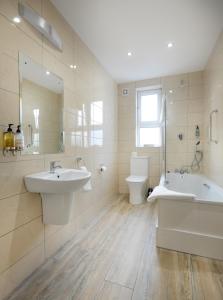 a bathroom with two sinks and a tub and a toilet at Imperial Hotel Galway in Galway