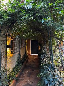 an entrance to a building with an arch and trees at Maison Nina, Suite d’exception in LʼÎle-Saint-Denis