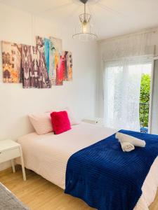 1 dormitorio con 1 cama grande con sábanas rojas y azules en Betis a la Orilla del Guadalquivir & Vistas a la Giralda, en Sevilla