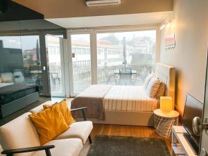 een woonkamer met een bed en een groot raam bij NiP Apartment | Porto City Center Near All Sights in Porto