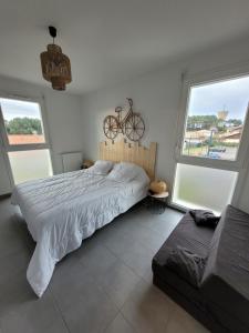 - une chambre avec un lit et un vélo sur le mur dans l'établissement Douceur Atlantique, à Mimizan