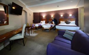 a hotel room with two beds and a couch at Imperial Hotel Galway in Galway
