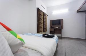 een slaapkamer met een bed en een televisie. bij Salamath Homestay in Cochin