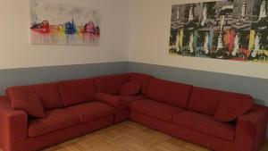 um sofá vermelho numa sala de estar com pinturas em B&S Domus Colosseo em Roma