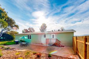 uma pequena casa branca com uma mesa e um guarda-chuva em Nature's Paradise em Watsonville