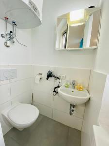 La salle de bains blanche est pourvue de toilettes et d'un lavabo. dans l'établissement Jainzen Einzimmerferienwohnung mitten im Zentrum, à Bad Ischl