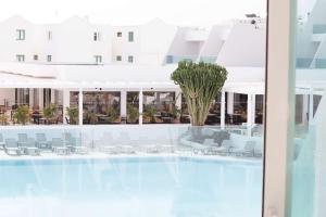 コスタ・テギセにあるRadisson Blu Resort, Lanzarote Adults Onlyのホテルのロビーを望む客室で、テーブルと椅子が備わります。