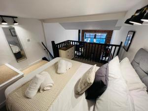 um quarto com uma grande cama branca e 2 almofadas em Apartment 6 Sullivan House em Hereford