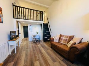 - un salon avec un canapé et un escalier dans l'établissement Apartment 6 Sullivan House, à Hereford