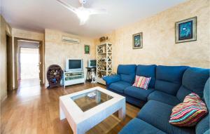 sala de estar con sofá azul y TV en 3 Bedroom Nice Home In Playa De Almazora, en San Antonio
