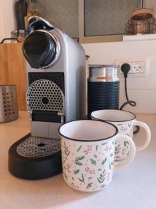 a toaster and two coffee cups on a counter at A romantic zimmer on the dead sea in Ovnat