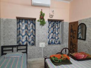 a room with two beds and two windows at Bubble Beds in Kolkata
