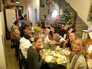 a group of people sitting at a table eating food at Pretty Backpackers House in Da Lat